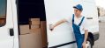 deliveryman-in-uniform-closing-car-door-delivery-e1618126435870.jpg