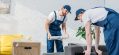 movers-wrapping-couch-with-roll-of-stretch-film-in-apartment-with-copy-space-e1618127910237.jpg